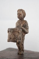 Dreams of Elders, Ceramic, 9.25H x 9.5W x 5D inches A ceramic sculpture by Michael Hermesh that depicts two children facing each other, one carries a drum and the other is wearing a bird mask