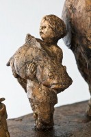 Fish Herder's Son, Ceramic Sculpture, 12H x 9.5W x 5D inches A ceramic sculpture by Michael Hermesh depicting a man carrying a briefcase and wearing a jestors hat while his son stands in front of him holding a large fish