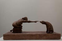 The Intentions of Gods, Ceramic, 12.5H x 5.5W x 5D Inches A ceramic sculpture by Michael Hermesh that depicts a seated woman leaning forward and pointing to the nose of a dog