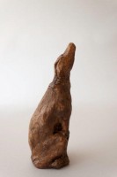 The Non Viability of Bridges, Two Piece Ceramic Sculpture, 10.25H x 6.25W x 6.25D inches A Ceramic sculpture by Michael Hermesh that depicts a man sitting on a pillar with his arms spread out as if to fly while a dog looks upward at him