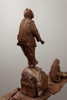 Waiting for the Ferryman, Ceramic, 27.5H x 22W x 6.5D Inches A ceramic sculpture by Michael Hermesh that depicts five passengers carrying suitcases standing on the backs of birds of prey that are riding in a boat
